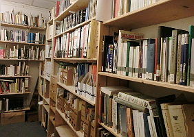 Raum mit hohen Bücherregalen voller Akten und Bücher.