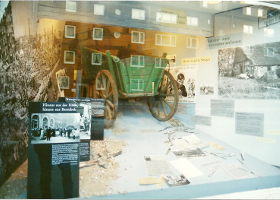 Ausstellung mit Bollerwagen in Schaufenster, historische Fotos und Texte