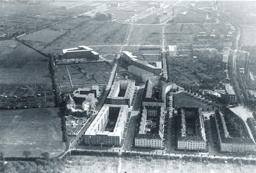 Elligersweg. Luftbild historischer Wohnsiedlung mit viel freier Fläche rundherum.