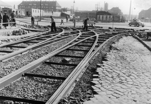 Arbeiter verlegen Straßenbahnschienen auf einer Kreuzung, 1950er Jahre.